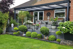 Classic anthracite veranda with lots of plants and a polycarbonate roof