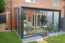 Anthracite pergola with glass sliding doors and polycarbonate sidewalls